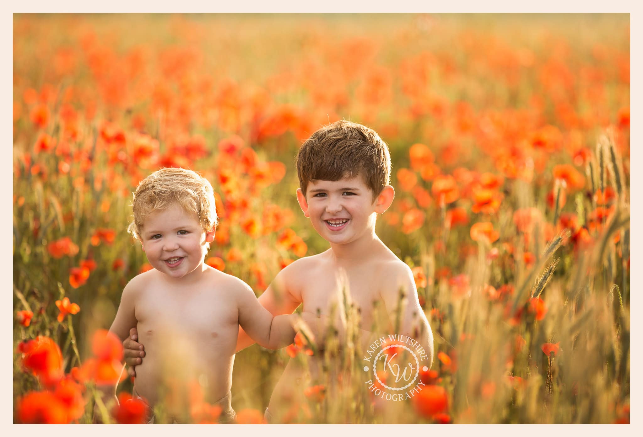 two young boys standing in a field of poppies