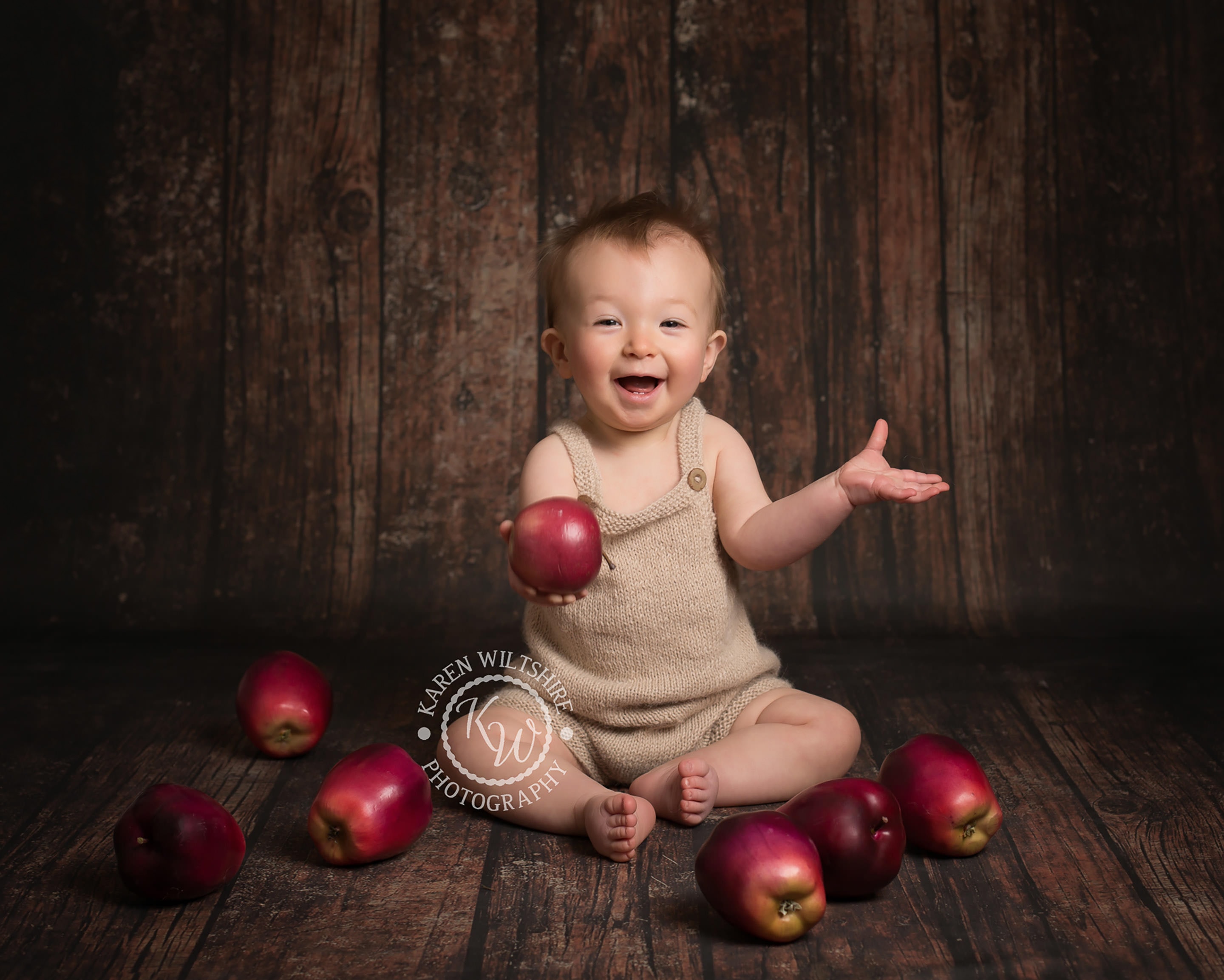 Baby Photographer Bournemouth, baby boy sitting on floor surrounded by apples