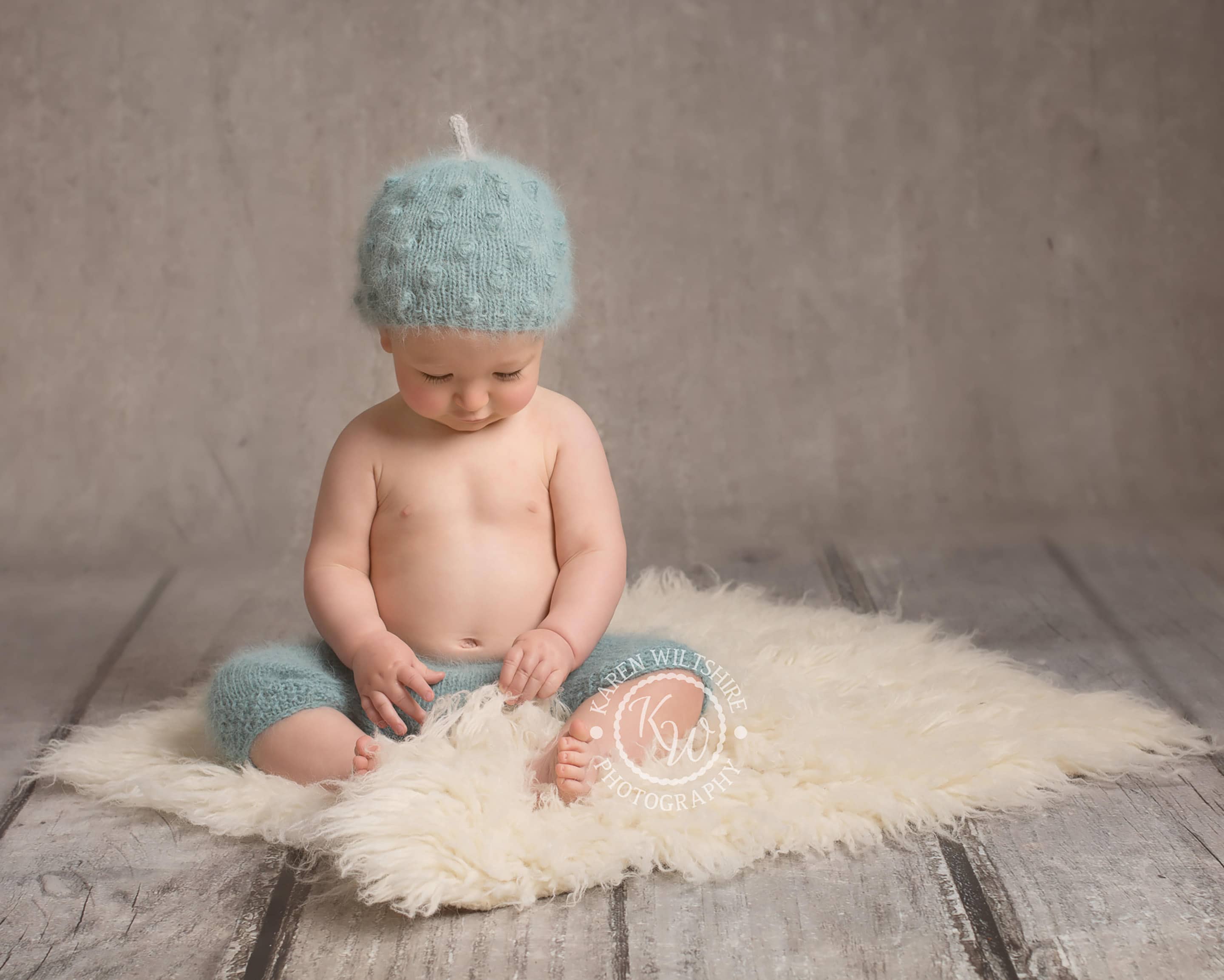 Cute Baby boy sitting on a fur rug at children & baby photography poole dorset