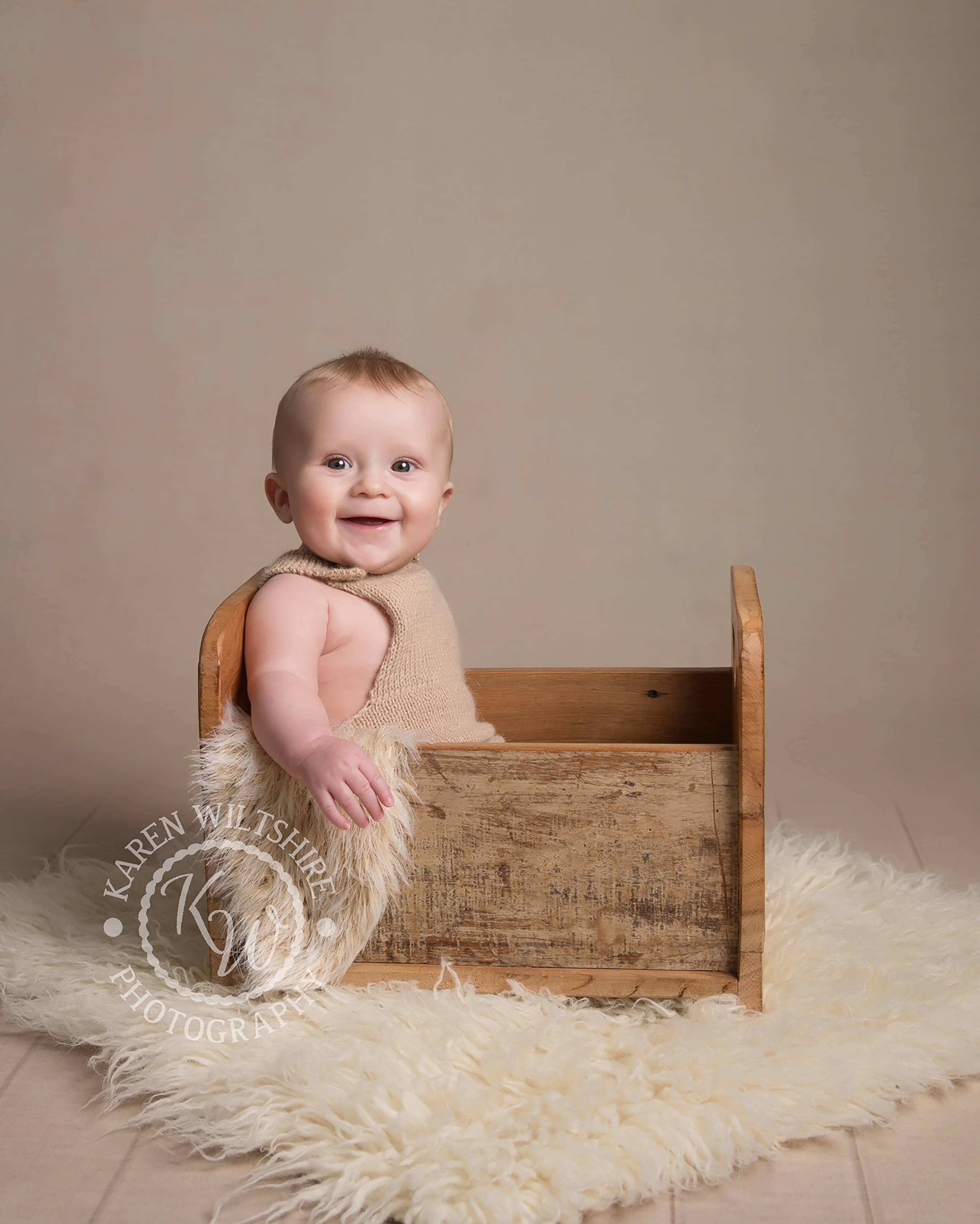 Baby Photography Poole , baby boy sitting in a wooden crate