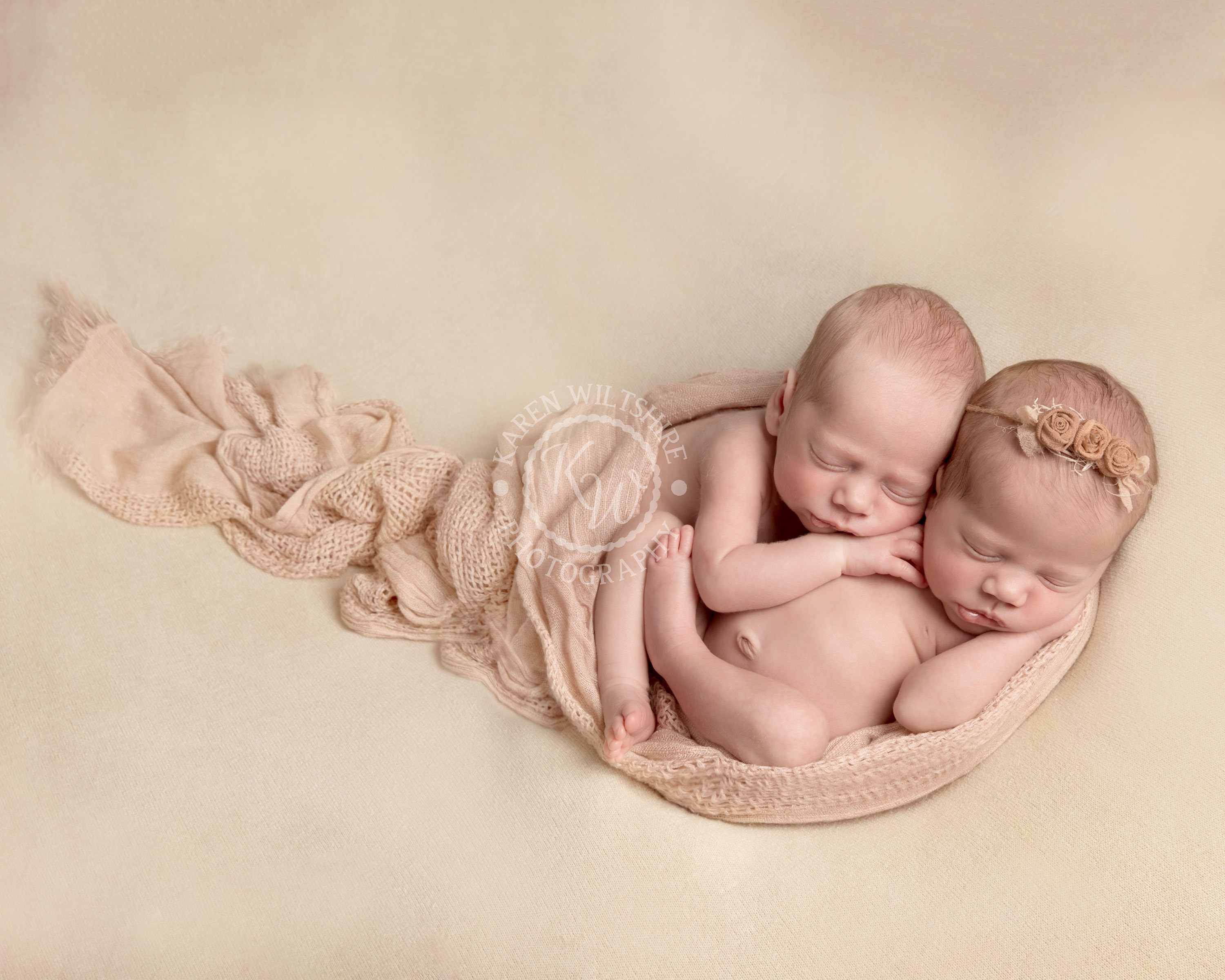 baby boy and girl twins on cream blanket