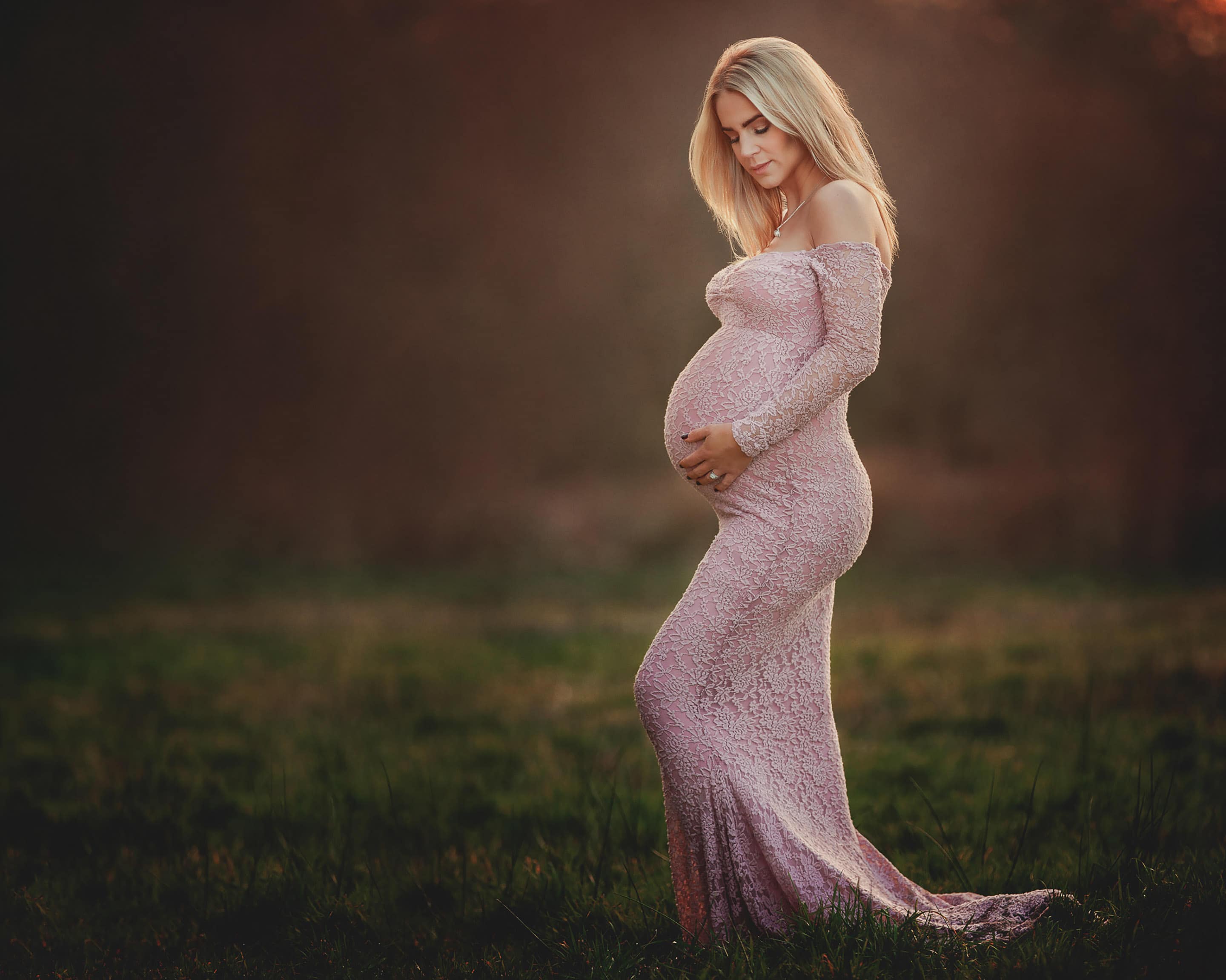 pregnant woman in pink dress holding her bump