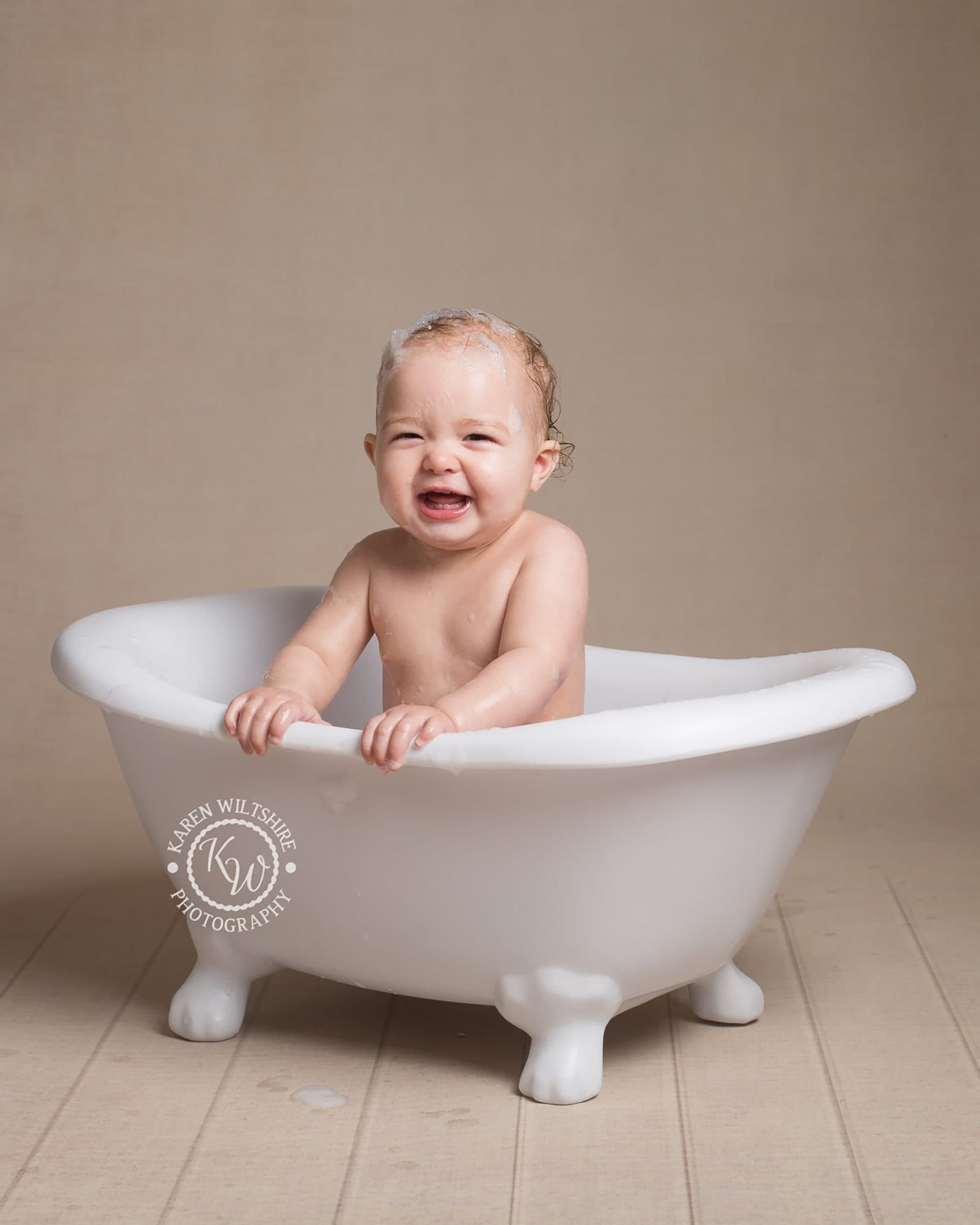 Baby in cute miniature roll top bath