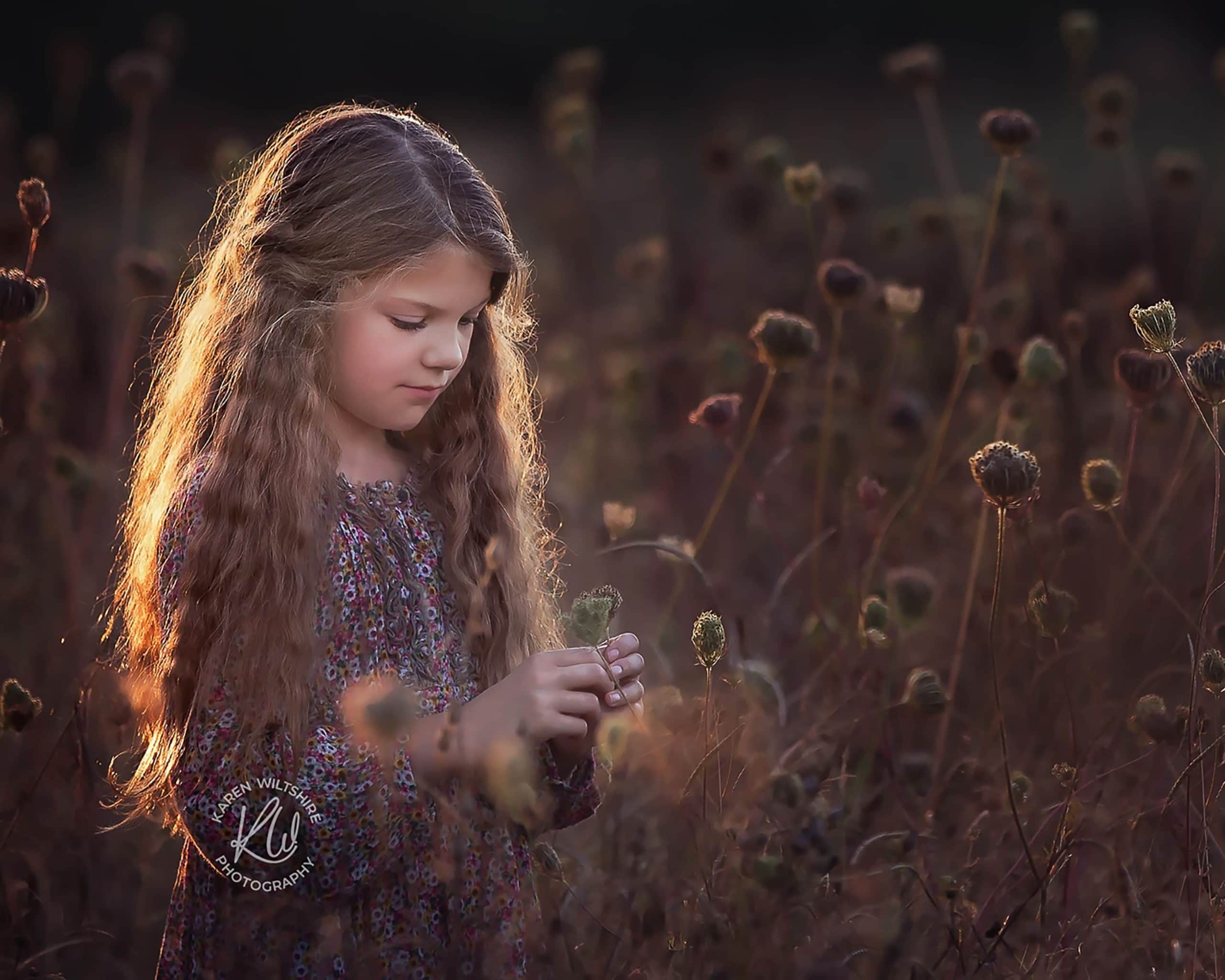 Long haired girl in field of seed heads