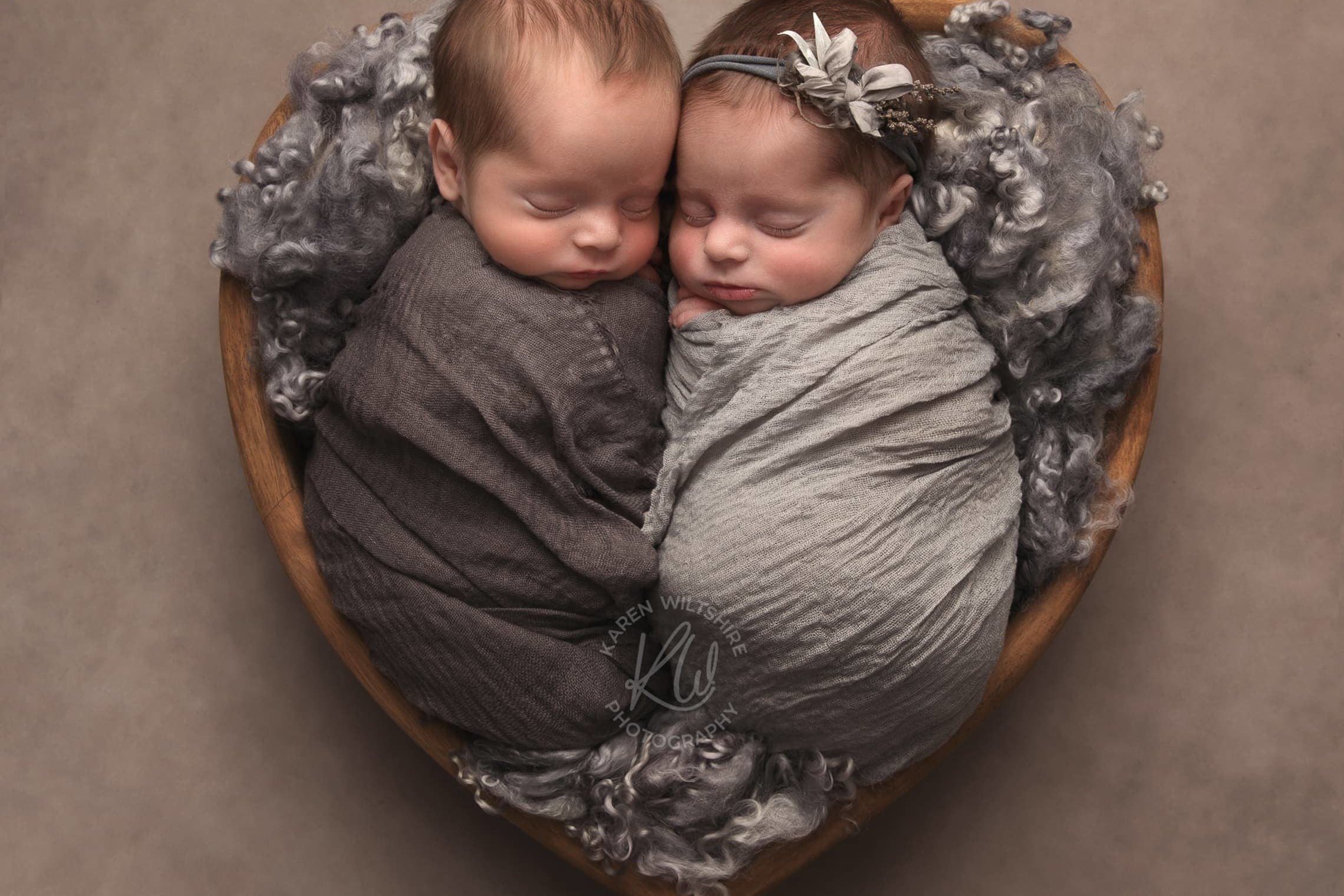 Boy and girl baby twins wrapped together sleeping