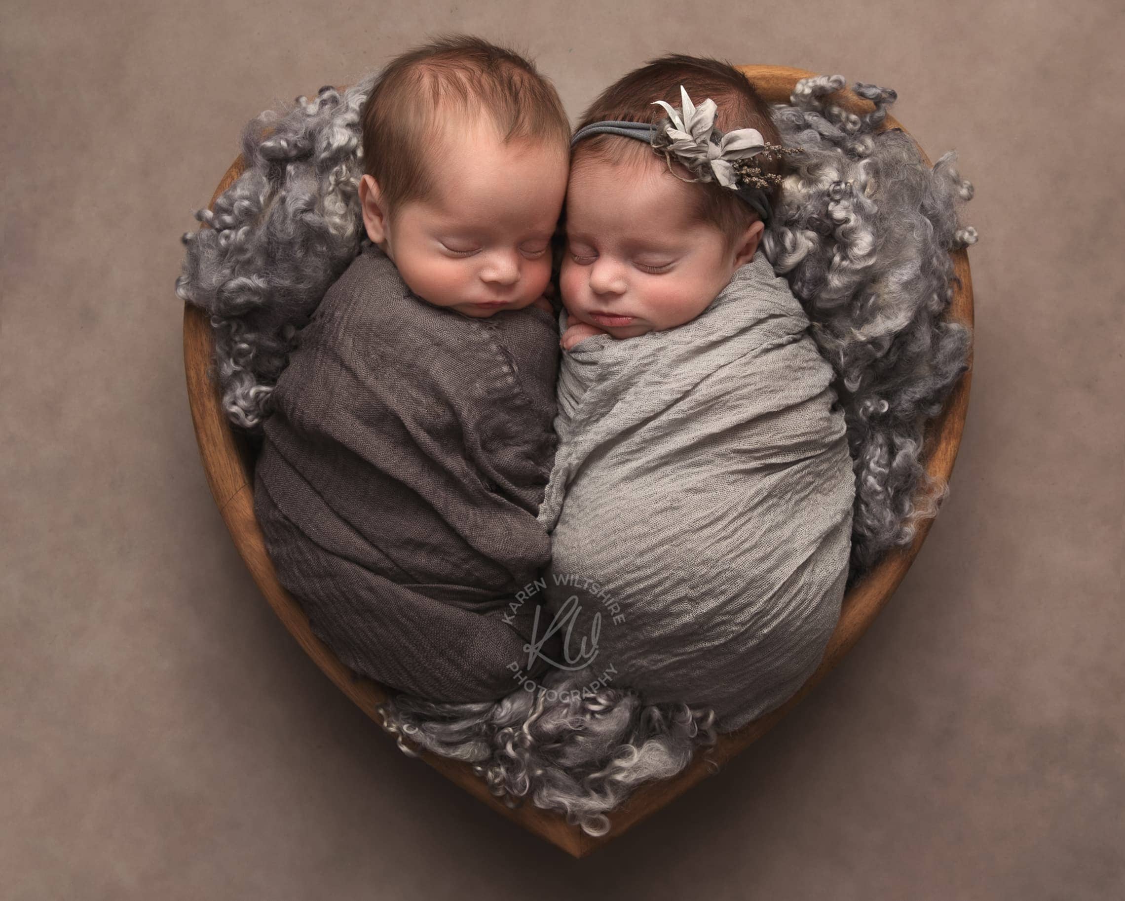 Boy and girl baby twins wrapped together sleeping