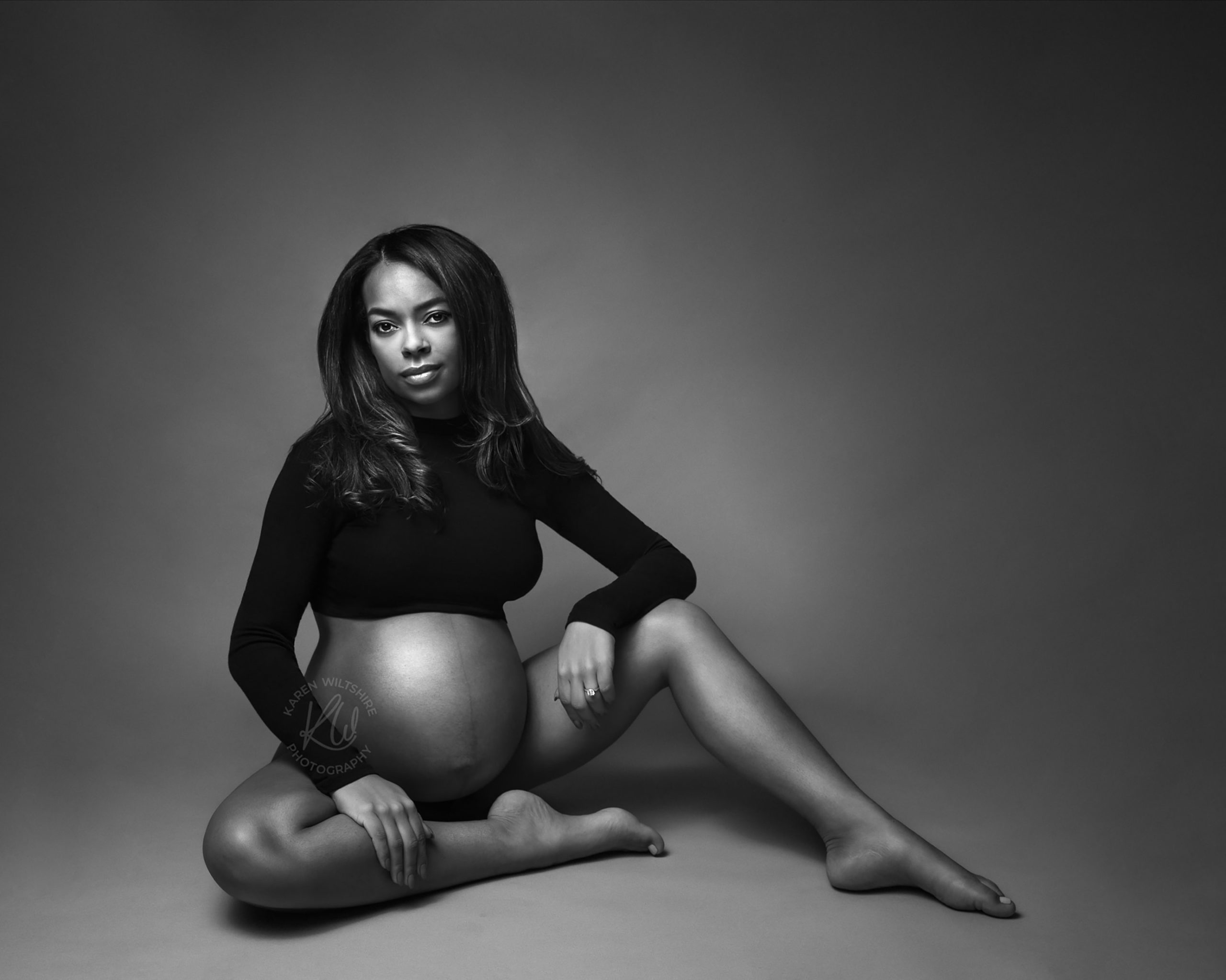 Black and White photo of pregnant lady sitting on the floor