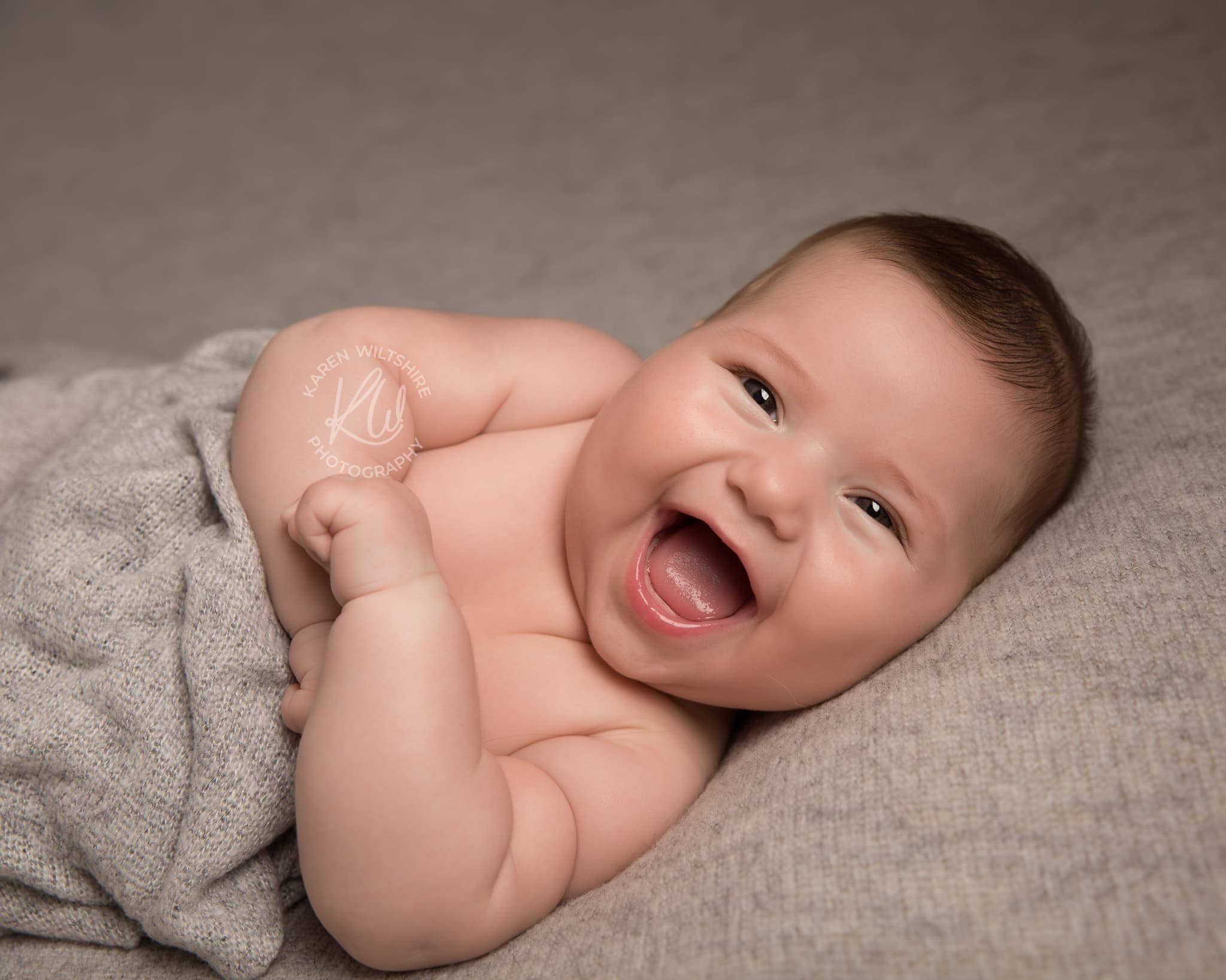 Very happy baby laughing at the camera